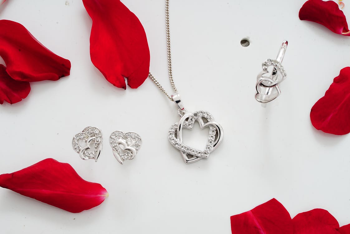 Set of shiny silver accessories among red petals